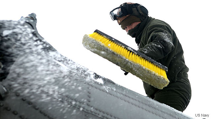 A crew chief with HMH-464 brushes snow and ice off of a CH-53 Super Stallion aboard <a href=/database/gps/3G5/>Camp Dawson</a>, West Virginia